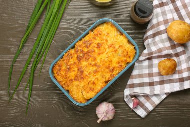 Ahşap zemin üzerinde lezzetli patates güveci olan yemek tabağı.