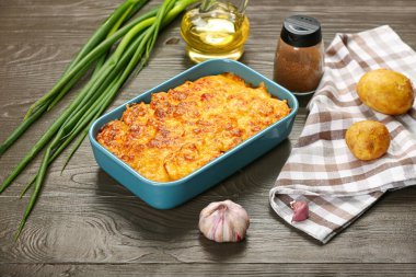 Ahşap zemin üzerinde lezzetli patates güveci olan yemek tabağı.