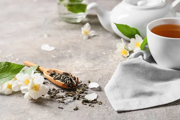 乾燥した緑茶 ホットドリンクのカップ ジャスミンの花を背景にスクープ — ストック写真