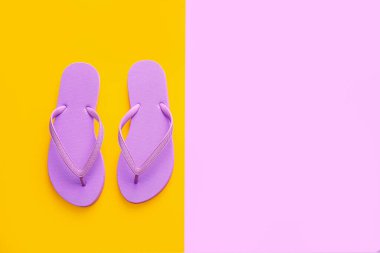 Renkli arka planda şık parmak arası terlikler