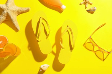 Plaj aksesuarları ve arka planda bir bardak meyve suyu olan kompozisyon