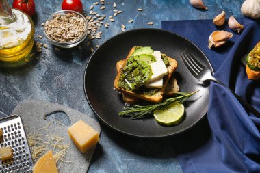 Lezzetli tost ve arkaplanda pesto soslu kompozisyon
