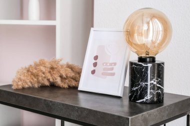 Lamba ve resim çerçevesi ışık duvarının yanında.