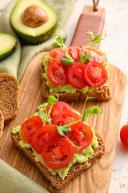Domatesli lezzetli bruschettalar ve arka planda guacamole, yakın plan.