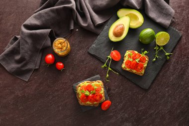 Esmer arka planda domates, guacamole ve hardallı lezzetli bruschettalar.