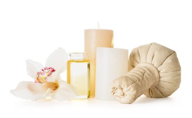 Beyaz arkaplanda yanan mumlar, bitkisel torbalar, gerekli yağ ve orkide çiçekleri.