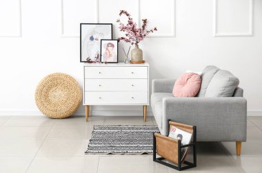 Modern odanın içinde çiçek açan dalları olan vazo.