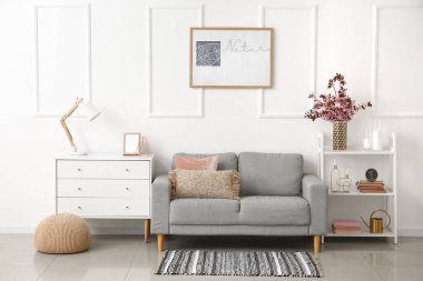 Oturma odasının iç tarafındaki rafta çiçek açan bir vazo.