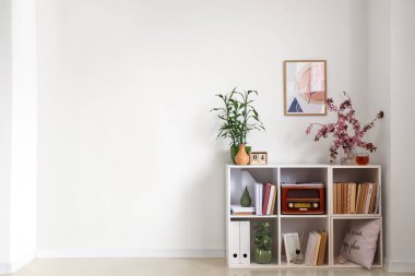 Çiçek açan dalları ve ışık duvarının yanında dekoru olan raf ünitesi