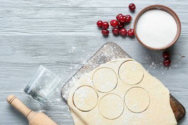 Renkli ahşap arka planda kirazlı hamur tatlısı için taze hamur kompozisyonu