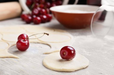 Renkli ahşap arka planda vişneli börek için taze hamur.