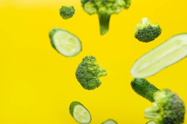 Arkaplanda uçan brokoli ve salatalık parçaları