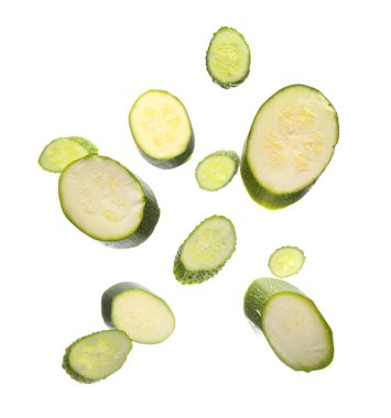 Beyaz arka planda uçan salatalık ve kabak dilimleri