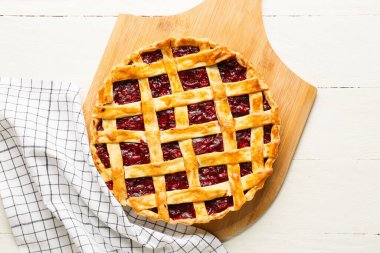 Hafif ahşap zemin üzerinde vişneli turta olan tahta.