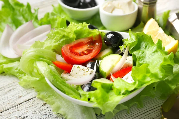 Bowl Tasty Greek Salad Ingredients Light Wooden Background Closeup — Stock Photo, Image