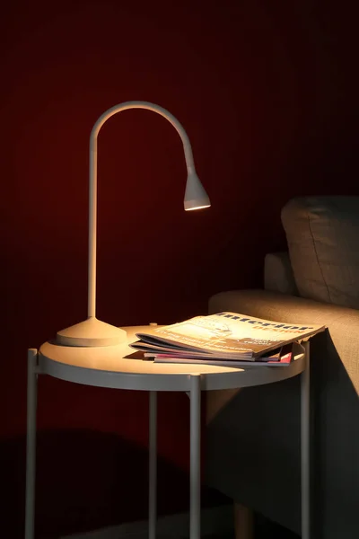 Glowing Lamp Magazines Table Dark Room — 스톡 사진