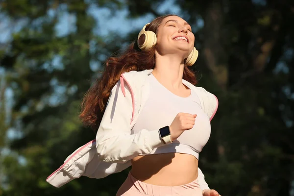 Sporty Young Woman Listening Music While Running Outdoors — Stock Photo, Image