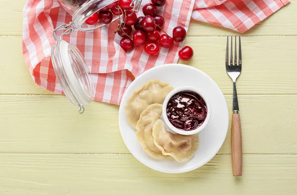 Lezzetli kirazlı hamur tatlısı ve ahşap arkaplanlı sos tabağı.