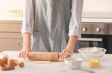 Kadın mutfak masasına para döküyor.