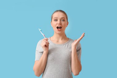 Arka planda diş fırçası olan sürpriz bir kadın.