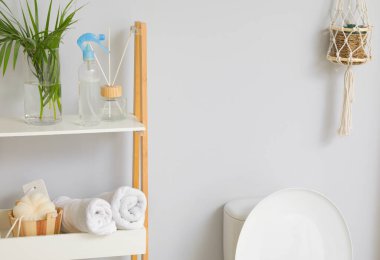 Banyosunda aksesuar ve klozet olan raf ünitesi.