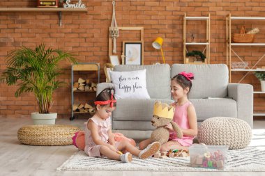 Evde oynayan şirin küçük kız kardeşler.