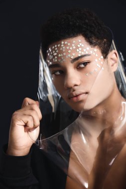 Siyah arka planda yakışıklı Afro-Amerikan bir adamın yaratıcı portresi.