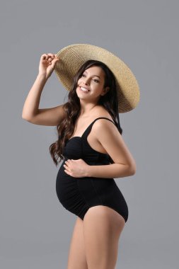 Gri arka planda güzel hamile kadın