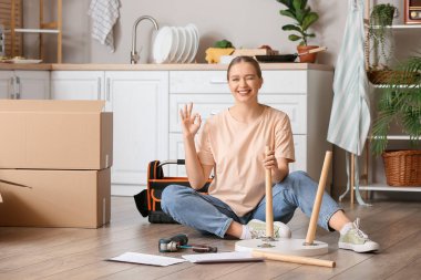 Evde mobilya montajlayan genç bir kadın.