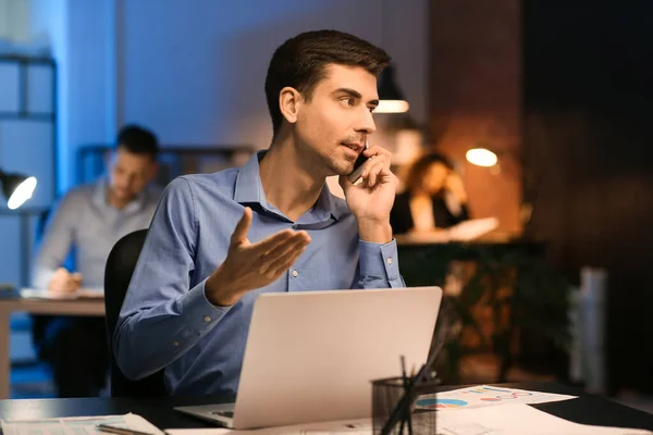 Young Man Talking Mobile Phone Office Night — Stock Photo, Image