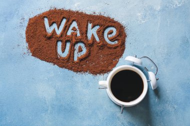 Sıcak kahve ve metin içeren çalar saat. Renk arkaplanındaki tozdan yapılmış.