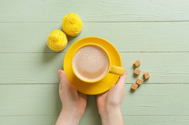 Kahveli kadın, kekler ve şeker renkli ahşap arka planda.