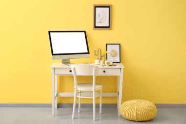 Renk duvarına yakın bilgisayarı olan modern işyeri