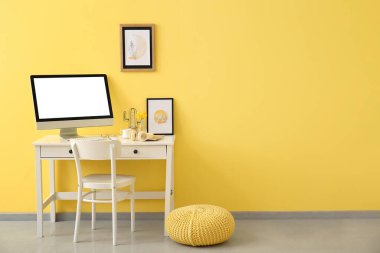 Renk duvarına yakın bilgisayarı olan modern işyeri