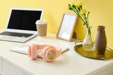 Renk duvarına yakın kulaklıklı modern işyeri