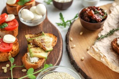 Farklı lezzetli bruschettalar ve hafif arka plandaki malzemeler, yakın plan