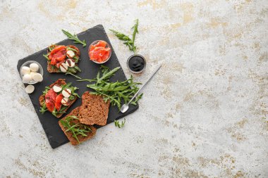 Mozarella peynirli, somonlu, roka soslu ve hafif arkaplanlı lezzetli bruschettalar.