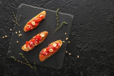 Esmer arka planda domatesli lezzetli bruschetalar.