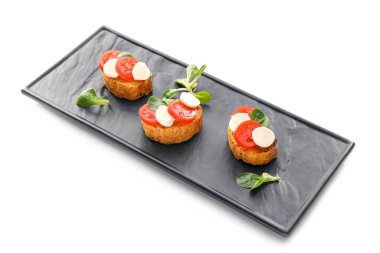 Mozarella peynirli lezzetli bruschettalar ve beyaz arka planda domatesler.