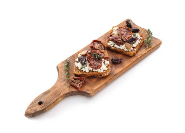 Peynirli lezzetli bruschettalar, güneşte kurutulmuş domatesler ve beyaz arka planda hurma.