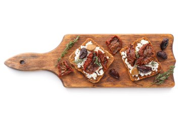 Peynirli lezzetli bruschettalar, güneşte kurutulmuş domatesler ve beyaz arka planda hurma.