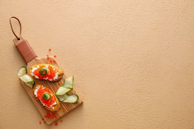 Peynirli lezzetli bruschettalar, kırmızı havyar ve renkli salatalık.