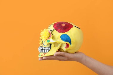 Meksika Ölüler Günü (El Dia de Muertos) için boyanmış insan kafatası ile el.