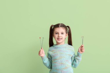 Renk arka planında konuşma düzeltmesi için logopedik araçlara sahip küçük kız