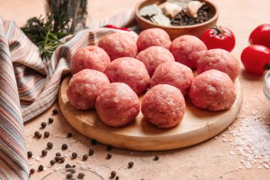 Hafif arka planda taze etten yapılmış çiğ pirzolaları olan ahşap tahta.