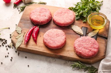 Hafif arka planda taze etten yapılmış çiğ pirzola ile kompozisyon