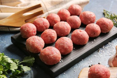 Renkli arka planda taze etten yapılmış çiğ pirzolaları olan ahşap tahta.