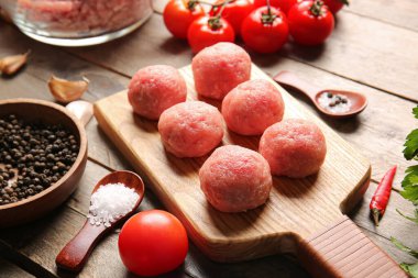 Ahşap arka planda taze etten yapılmış çiğ pirzola ile kompozisyon