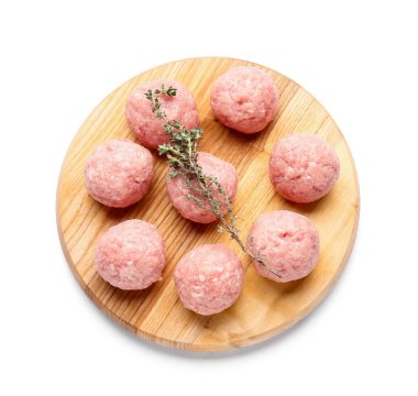 Beyaz arka planda taze etten yapılmış çiğ pirzolaları olan ahşap tahta.