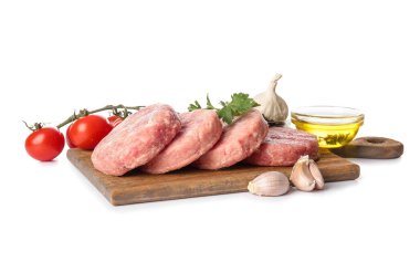 Beyaz arka planda taze et ve malzemelerden yapılmış çiğ pirzolaları olan tahta tahta tahta.